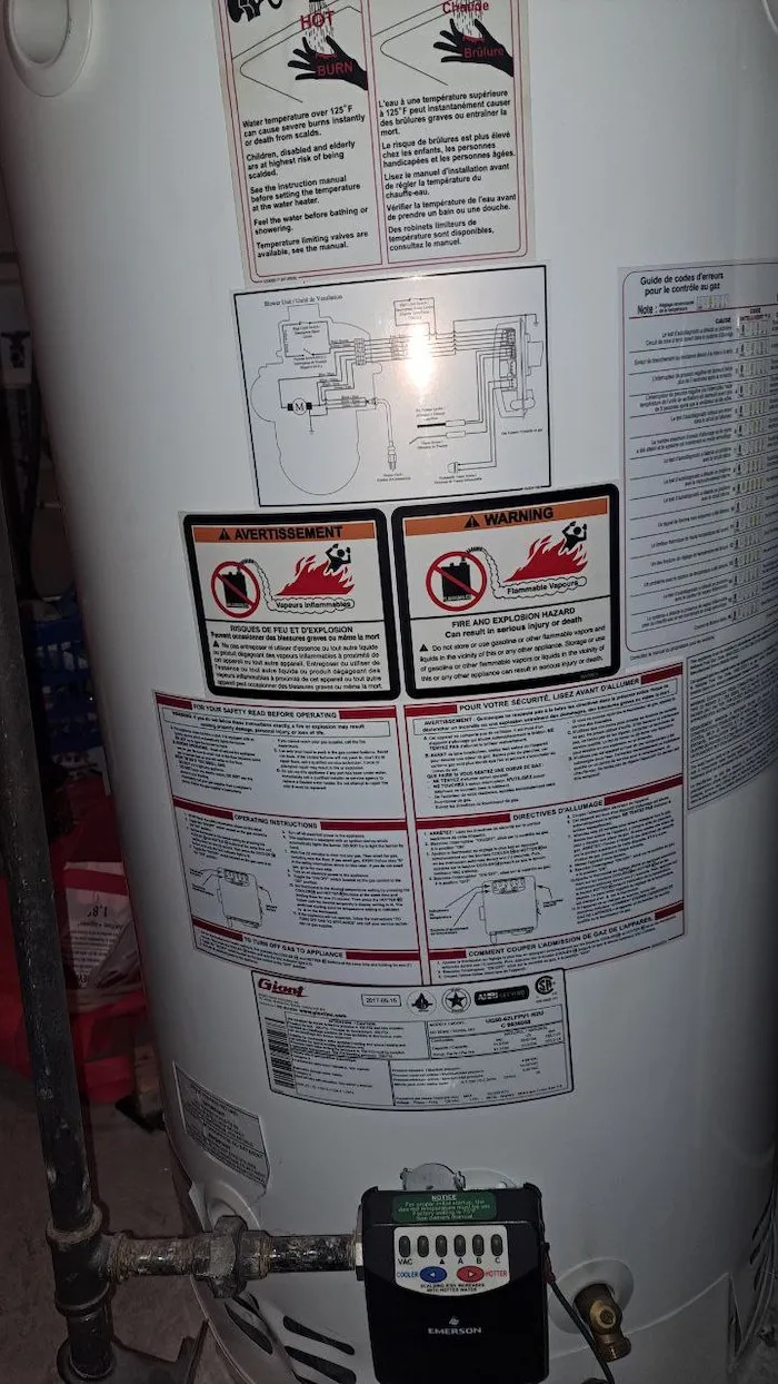 Close-up of a water heater warranty label and documentation
