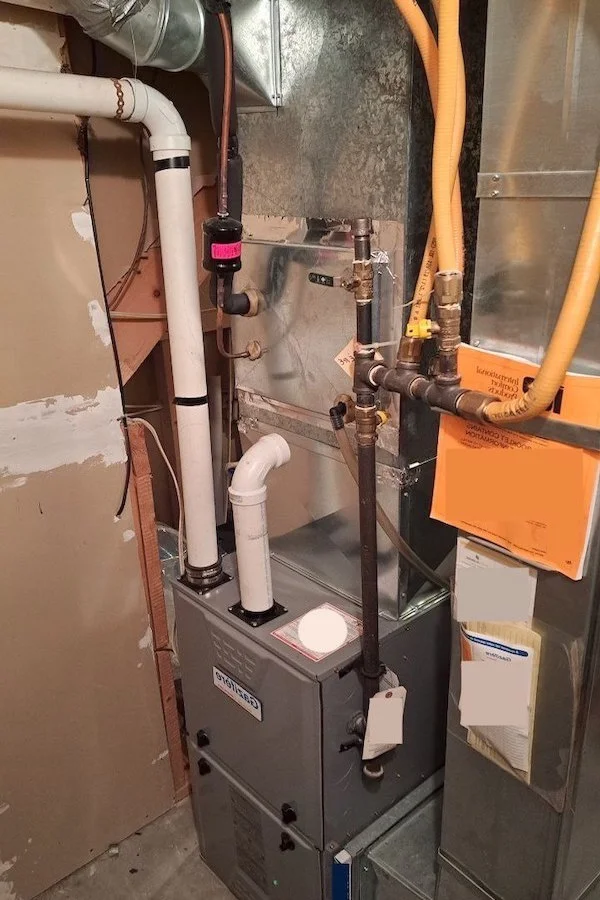 Une fournaise à gaz résidentielle haute et beige, avec son panneau avant en place affichant le logo du fabricant.